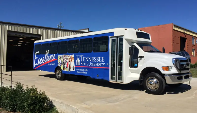 Shuttle bus with blue graphics and white lettering along its side