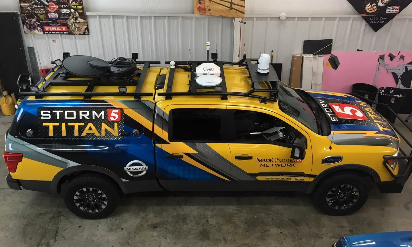 Yellow and black pickup with large graphics and equipment on its roof