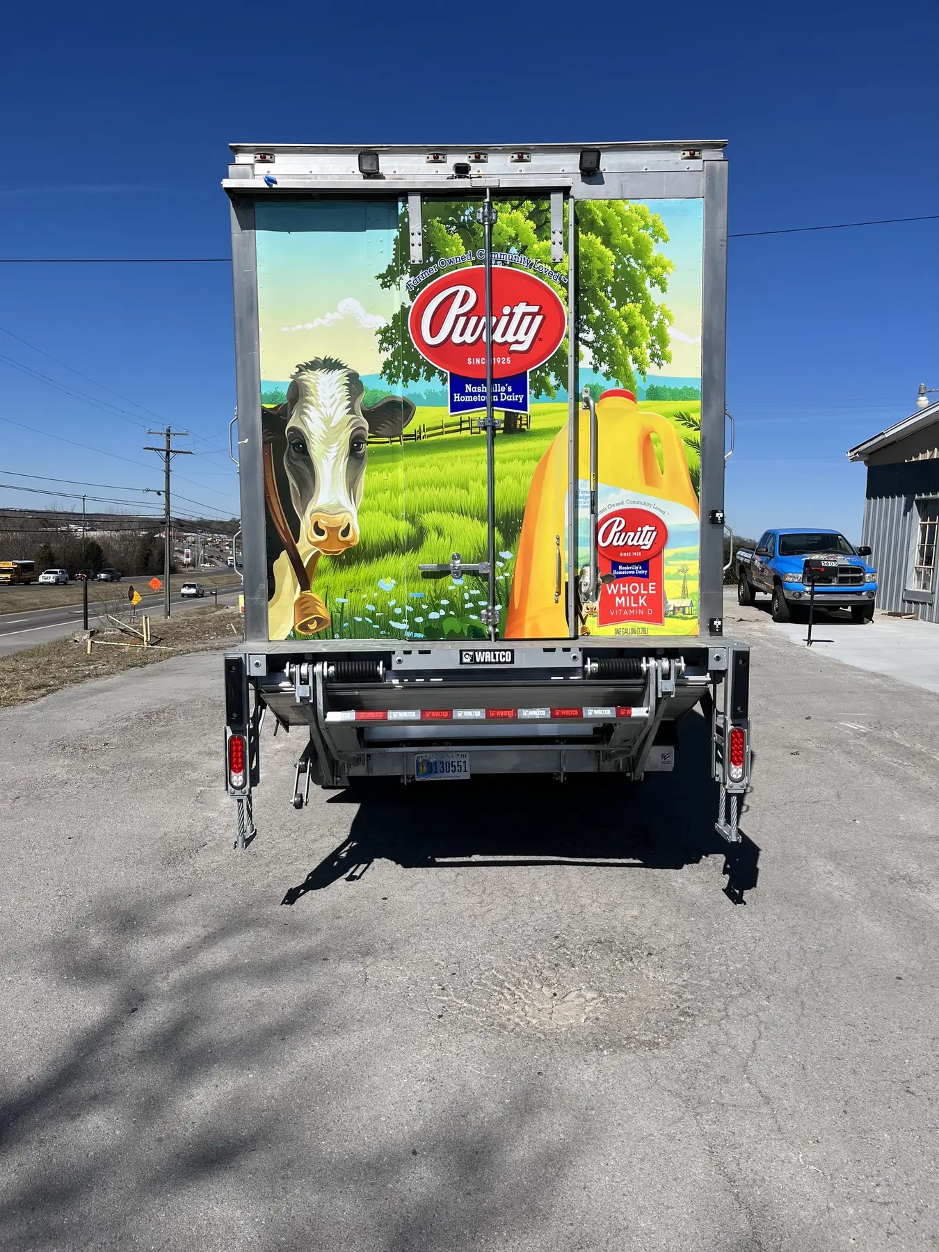 Rear of a box truck covered in colorful dairy product graphics
