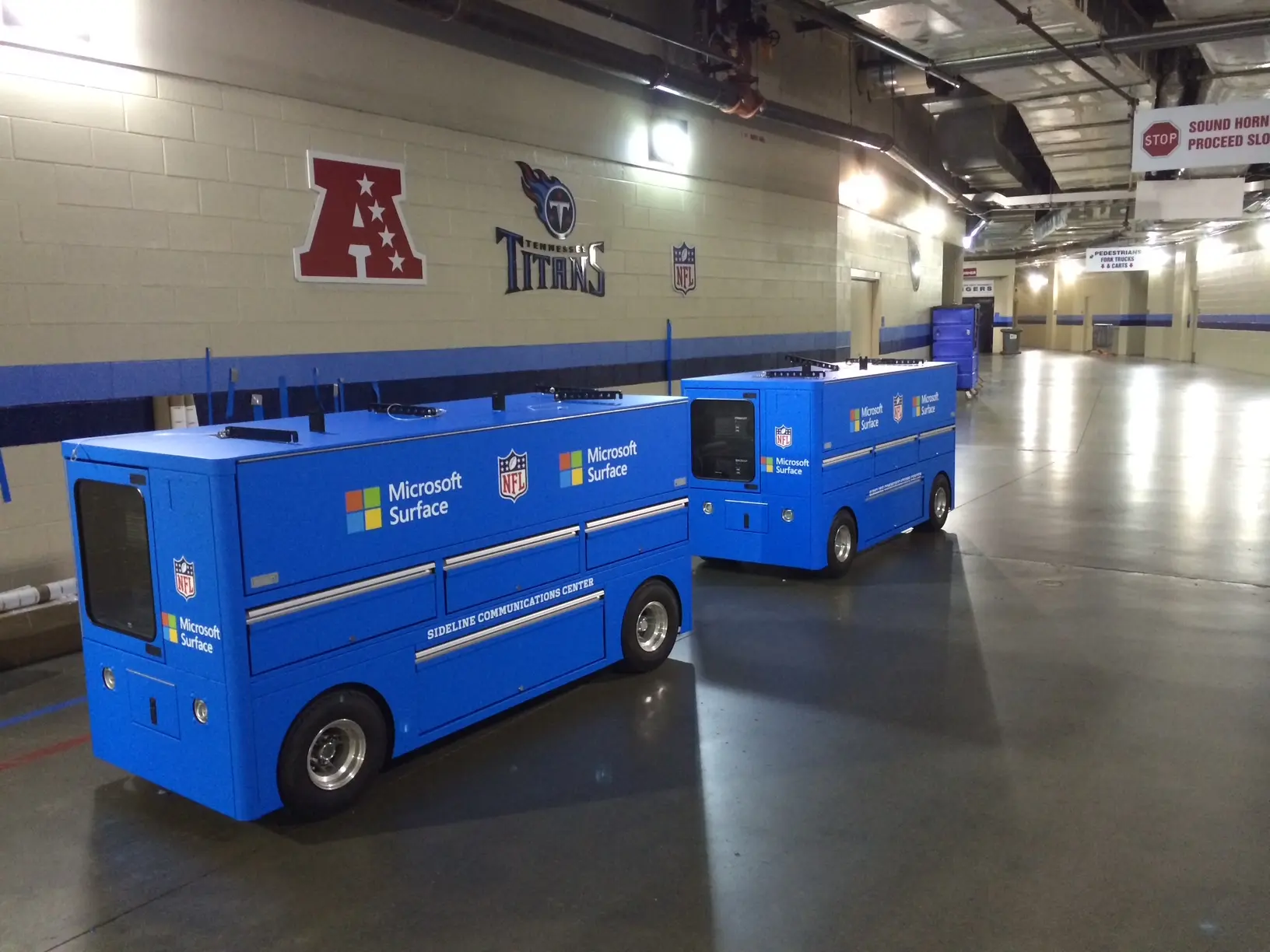 Blue mobile equipment units with yellow and white lettering inside the shop