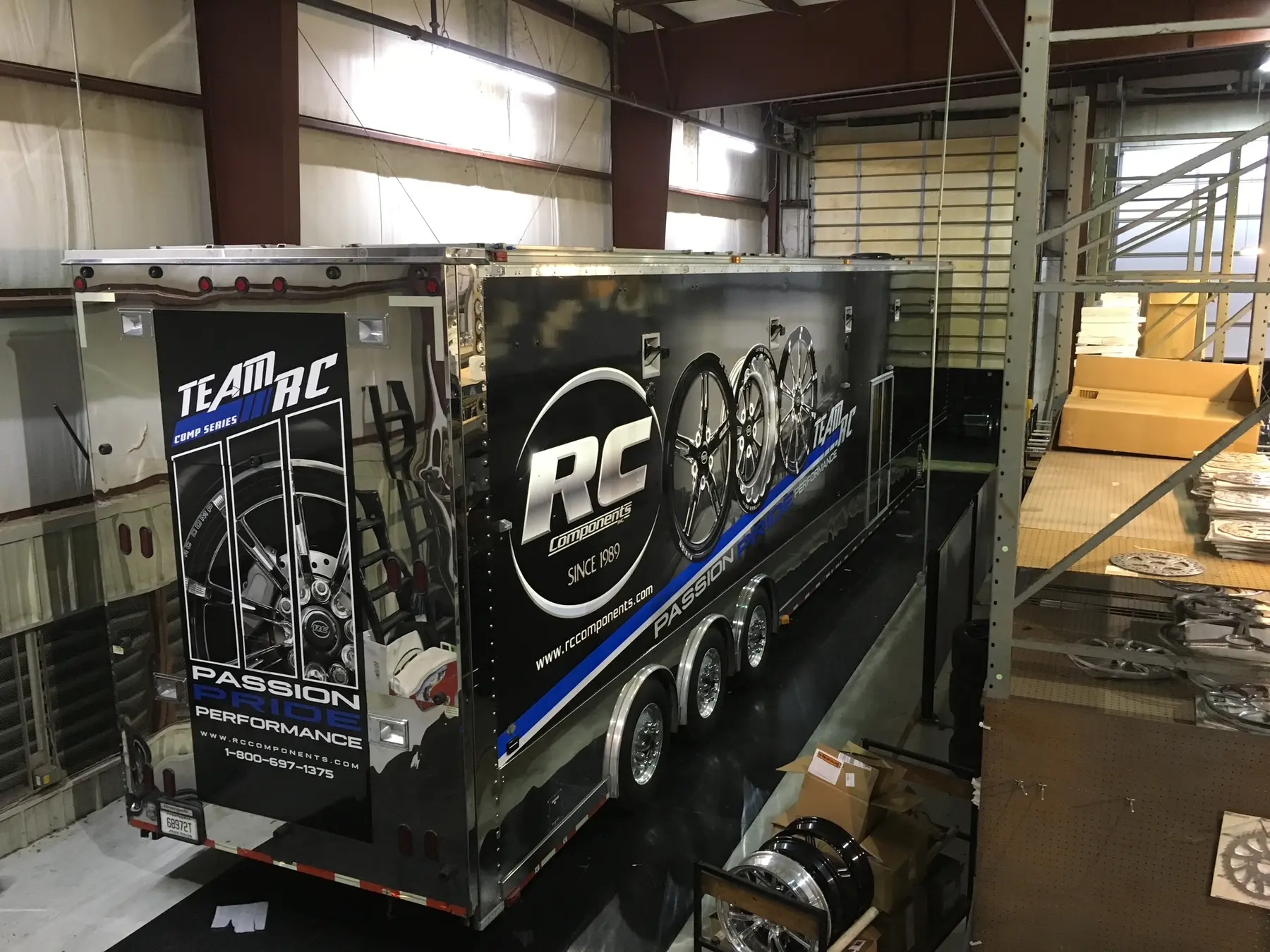 Black enclosed trailer with large monochrome graphics inside the shop
