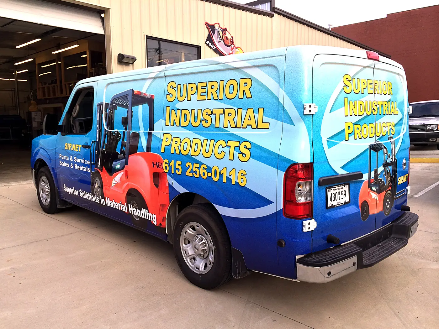 Blue work van with colorful industrial product graphics