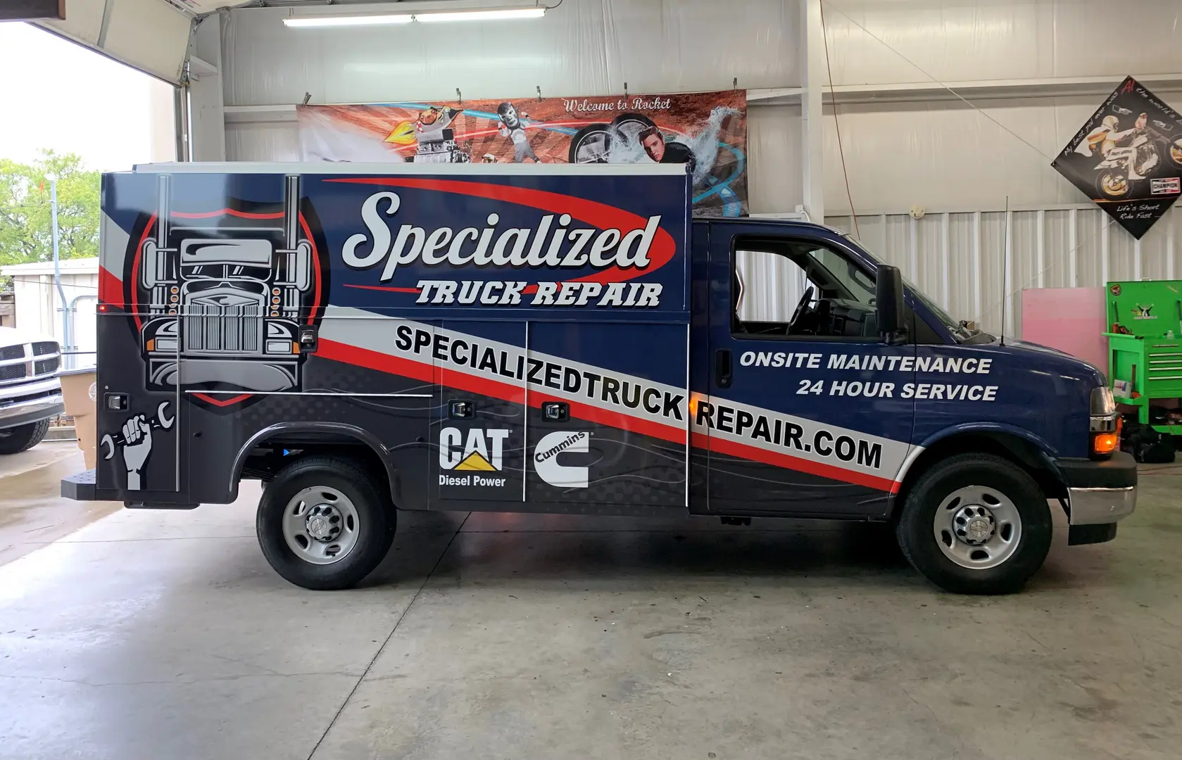 Black service truck with red, green and white business graphics