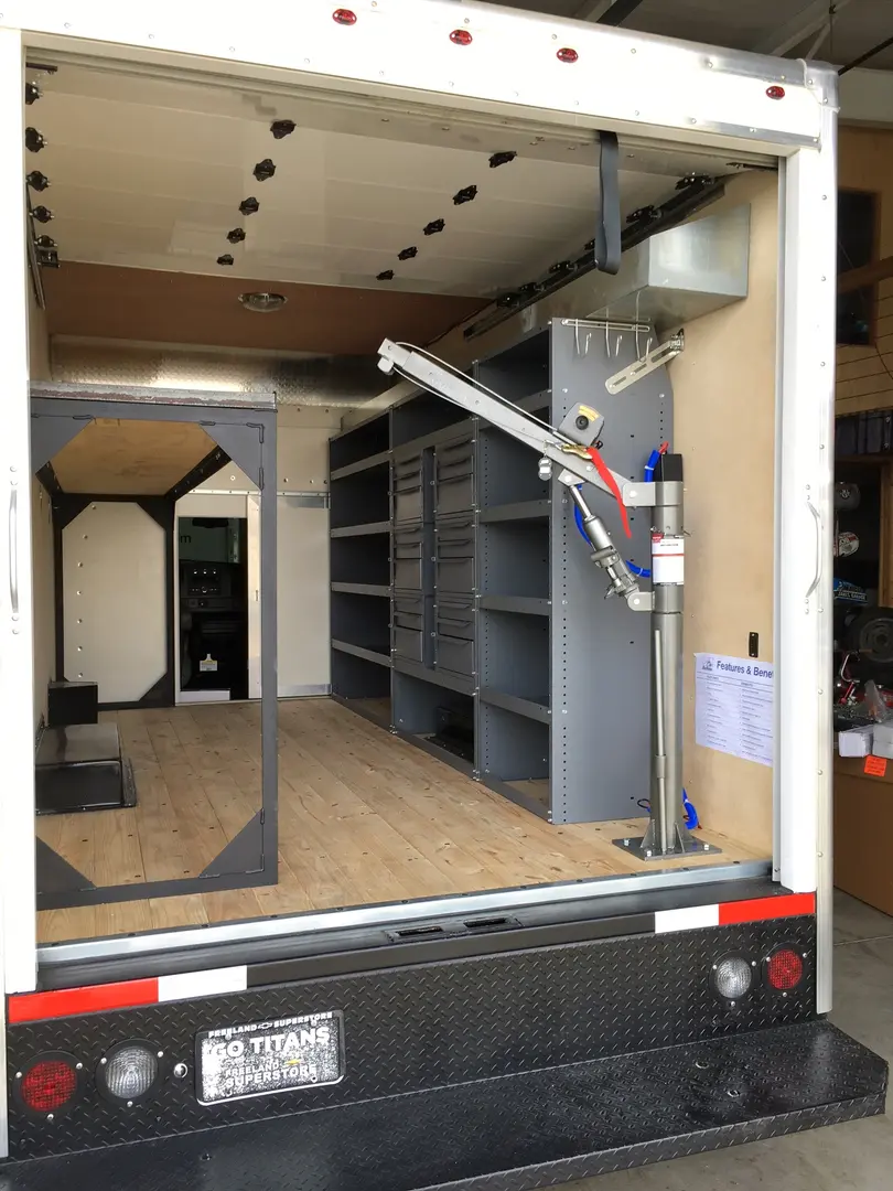 Open trailer interior with wood flooring and storage units