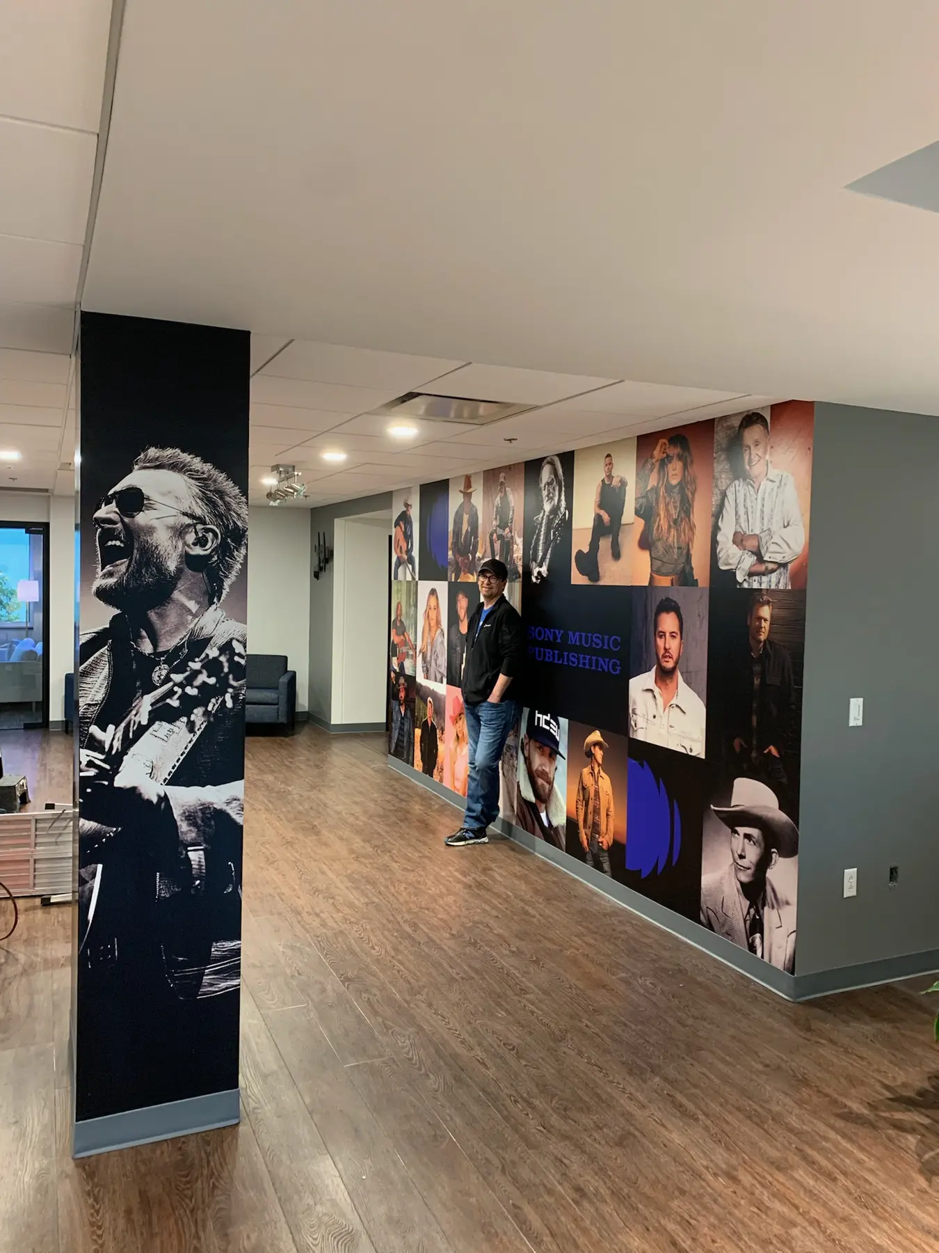 Portrait and collage wall graphics lining an interior hallway